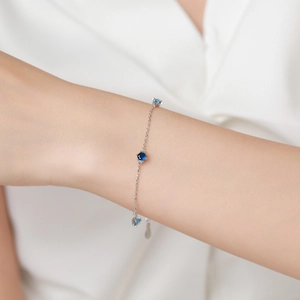 Elegant S925 sterling silver bracelet featuring three round blue gemstones on a delicate chain