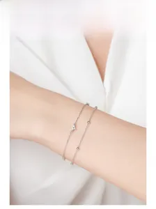 Detail of silver double-layered clover bracelet with micro-pave charms on a model wrist
