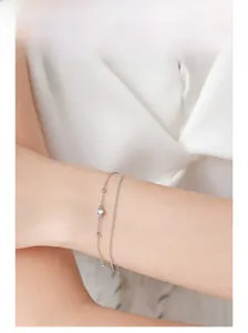 Detail of a minimalist double-layer S925 silver bracelet featuring a small round stone