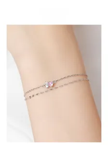 Macro detail of S925 silver double-layer bracelet with pink heart zircon and butterfly charm