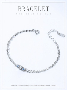 Détail macro du bracelet double en argent S925 avec cœur et zircons bleus brillants