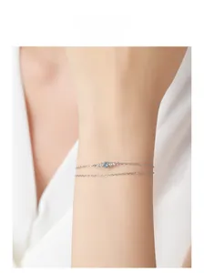 Détail du bracelet en argent sterling S925 avec zircons bleus et clairs sur poignet féminin