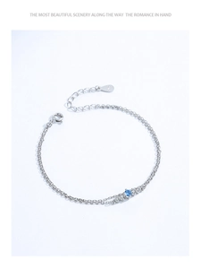 Détail macro du bracelet à double chaîne en argent S925 avec zircons bleus et blancs