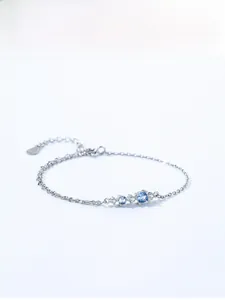 Detailed macro of S925 sterling silver bracelet featuring blue gems and a fine link chain