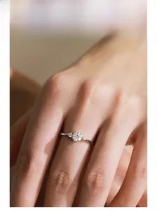 Close-up of S925 silver ring featuring three sparkling round zirconia stones on model hand
