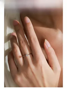 Gros plan d'une bague solitaire classique en argent S925 portée par un mannequin