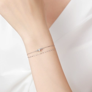 Bracelet double rang en argent S925 avec zircon en cœur porté sur un poignet féminin