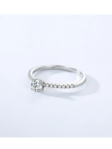 Detailed view of six-prong silver engagement ring with round cubic zirconia and side stones