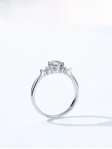 Close-up of a silver six-prong engagement ring featuring a round brilliant-cut gemstone