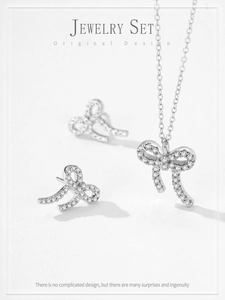 Gros plan d'un ensemble de bijoux nœud en argent S925 avec zircons brillants sur fond blanc