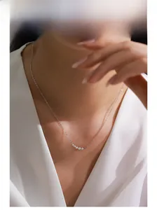 Model wearing a delicate S925 sterling silver curved necklace with seven gradient cubic zirconia