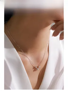 Detail of S925 sterling silver four-pointed star necklace on model neckline