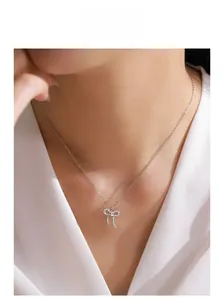 Gros plan d'un collier nœud en argent avec zircons porté par un mannequin élégant