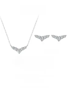 Macro detail of V-shaped sterling silver jewelry set featuring shimmering round-cut crystals