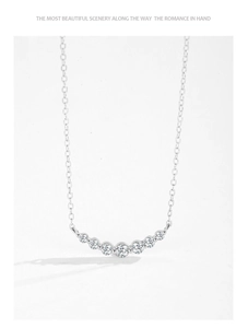 Detail of S925 sterling silver curved necklace with seven sparkling round cubic zirconia