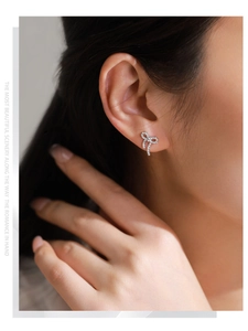 Gros plan de boucles d'oreilles nœud en argent S925 avec zircons brillants sur mannequin