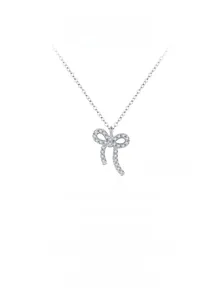 Macro shot of silver bow pendant with cubic zirconia on an O-chain necklace