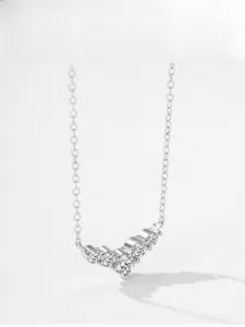Macro shot of V-shaped sterling silver necklace pendant with five graduated round zirconias