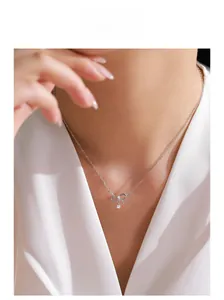 Close-up of S925 sterling silver bow necklace with sparkling zircon on a model neck