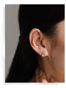 Detail of double star S925 silver stud earrings with sparkling cubic zirconia on ear