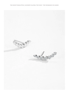 Close-up of S925 sterling silver curved crawler earrings with gradient cubic zirconia