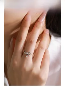 Détail d'une bague nœud en argent S925 avec pendentif en zircon portée au doigt