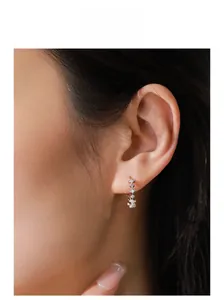 Detailed close-up of sparkling S925 sterling silver star earrings on model ear