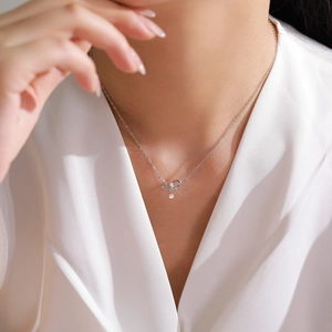 Elegant S925 sterling silver necklace with zircon bow pendant worn on a female model