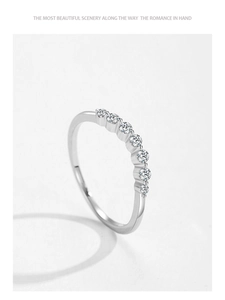 Détail macro d'une bague en argent S925 avec 7 zircons scintillants sur un fond blanc pur