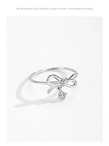 Détail d'une bague nœud en argent S925 avec zircon scintillant et pierre centrale suspendue