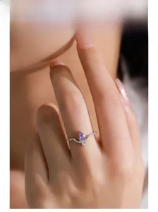 Vue macro d'une bague en argent en forme de V avec améthyste violette sur le doigt