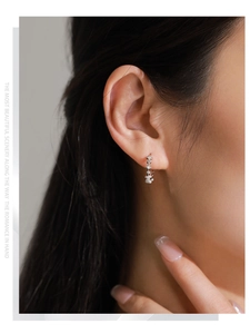 Close-up of S925 sterling silver sparkling star drop earrings on model's earlobe