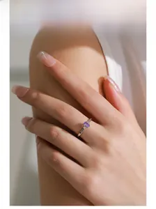 Close-up of S925 silver ring featuring an oval purple gemstone worn by a model
