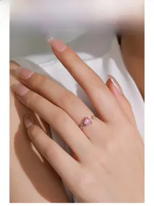 Detail of S925 silver ring featuring pink heart-shaped crystal on female finger