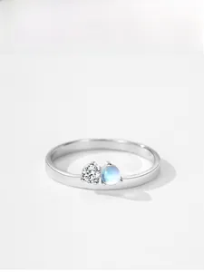 Detailed view of silver ring featuring a round zircon and translucent blue moonstone