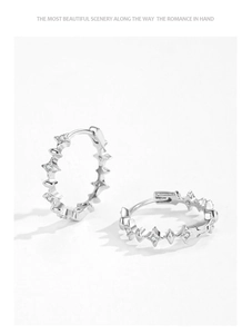 Macro detail of S925 sterling silver hoop earrings with sparkling four-pointed stars