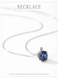 Gros plan d'un collier avec pierre bleue taillée et serti à six griffes en argent