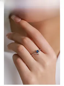 Close-up of S925 silver ring with blue zircon and pavé setting on model finger