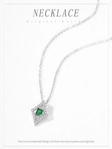 Gros plan du pendentif argenté en losange avec zircon vert émeraude et pierres blanches