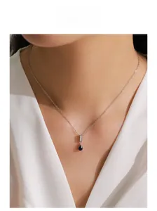 Dettaglio della collana in argento S925 con pendente a goccia blu su modella