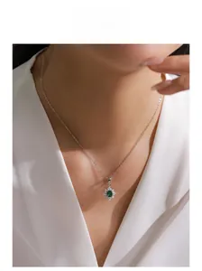 Gros plan d'un collier flocon de neige en argent avec pendentif émeraude sur un mannequin