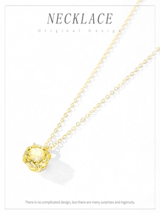 Macro shot of 18K gold necklace with a large yellow round-cut zircon pendant on white base