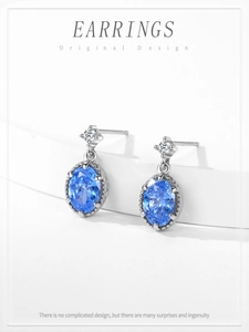 Détail de boucles d'oreilles en argent avec zircon bleu ovale et petits cristaux