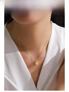 Close-up of a model wearing a luxury gold pendant necklace with a citrine gemstone