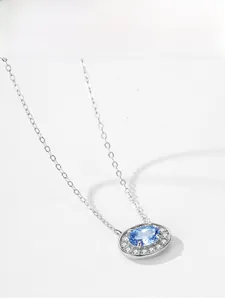 Vue détaillée d'un pendentif ovale en pierre bleue en argent S925 avec zircons blancs