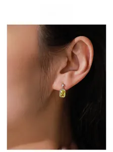 Detailed close-up of a square yellow zircon silver stud earring on a model's ear