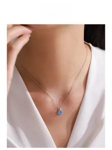 Gros plan du collier en argent 925 avec pendentif ovale bleu sur le cou d'un mannequin