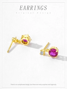 Detail view of gold S925 silver earrings with red zircon and hollow crown base design