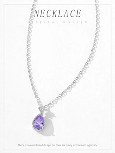 Detailed close-up of a pear-shaped purple crystal pendant on a silver S925 necklace