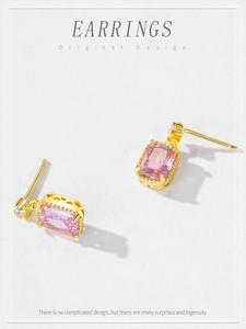 Detail view of pink rectangular zircon earrings with gold plating and white stone accent